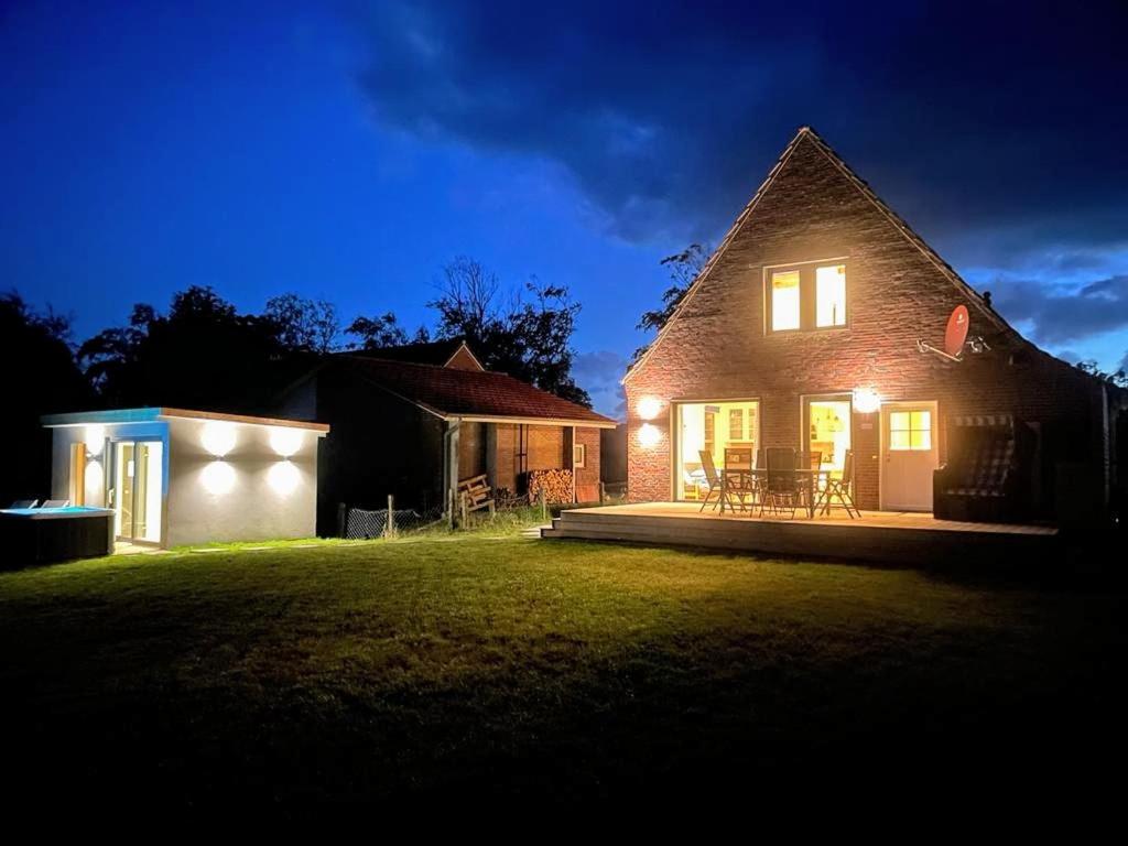 a house with lights on the side of it at night at Osterdeich 38 in Dornum