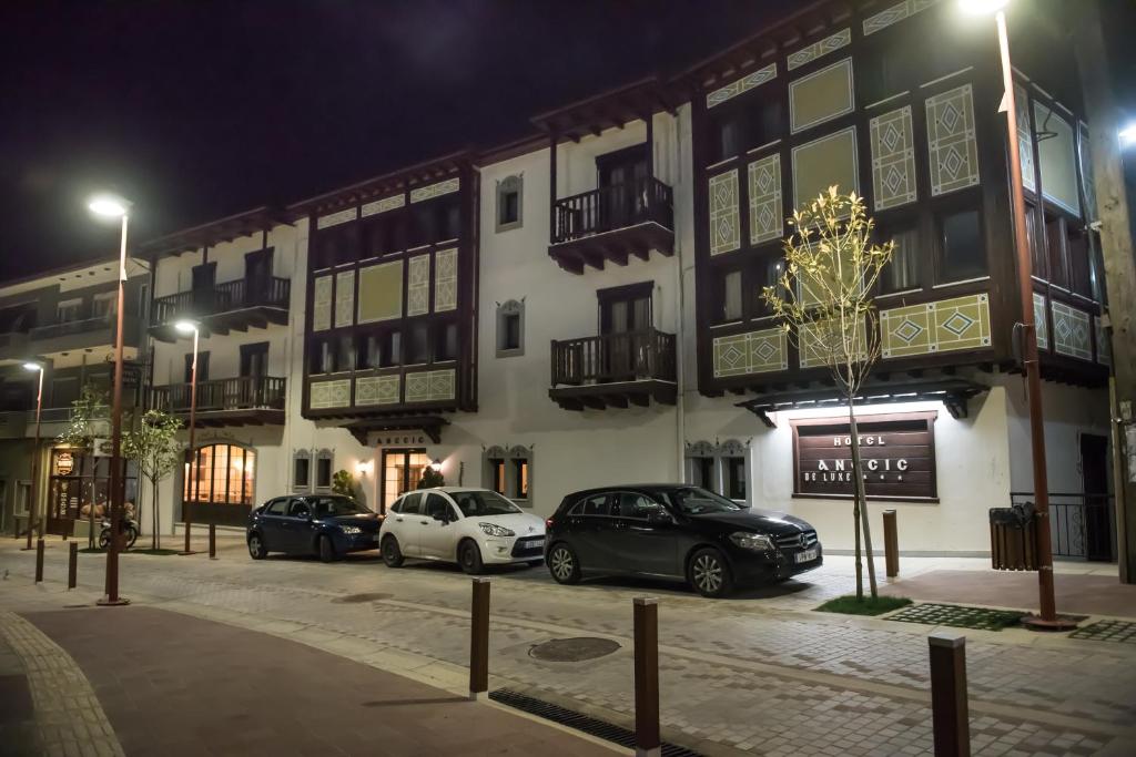 dos autos estacionados frente a un edificio por la noche en Anesis Hotel en Karpenísion