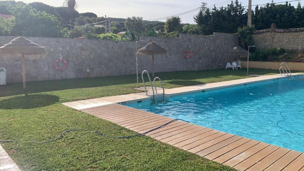 a swimming pool with umbrellas in a yard at Hotel Nómadas in Vejer de la Frontera