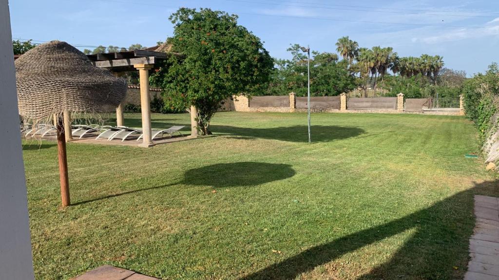 a grassy yard with a golforie and a tree at Hotel Nómadas in Vejer de la Frontera