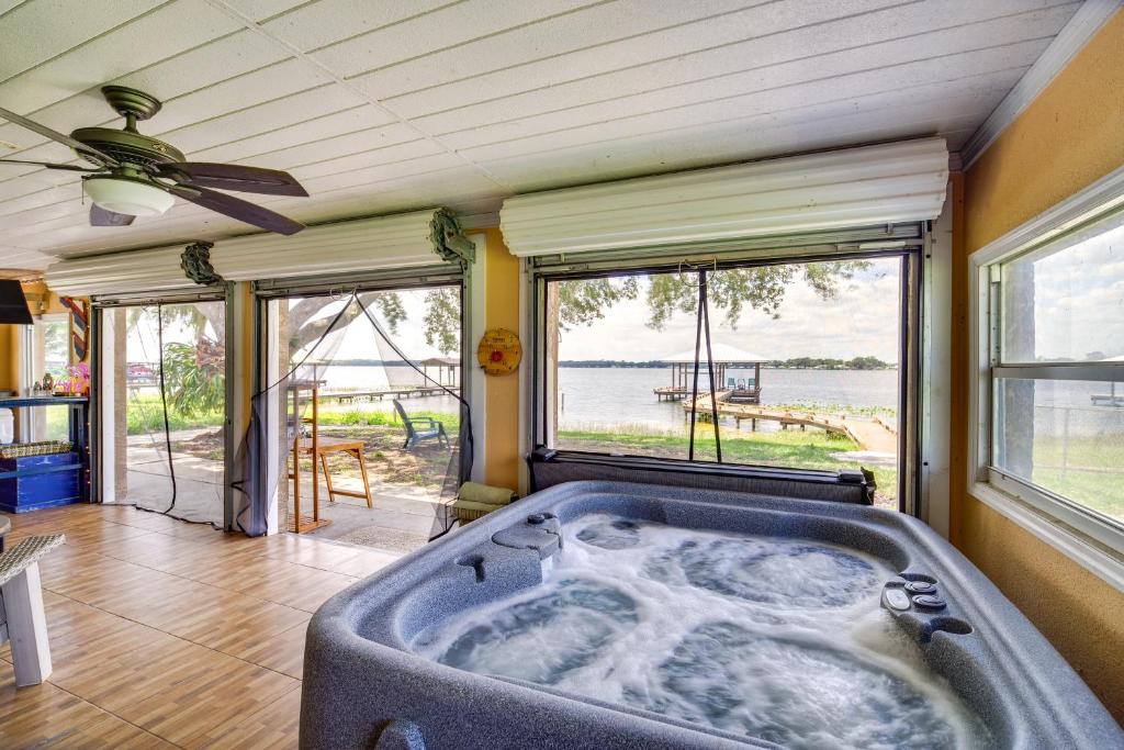 bañera grande en una habitación con ventanas en Lake Francis Lily Pad - Home with Hot Tub and Dock!, en Lake Placid