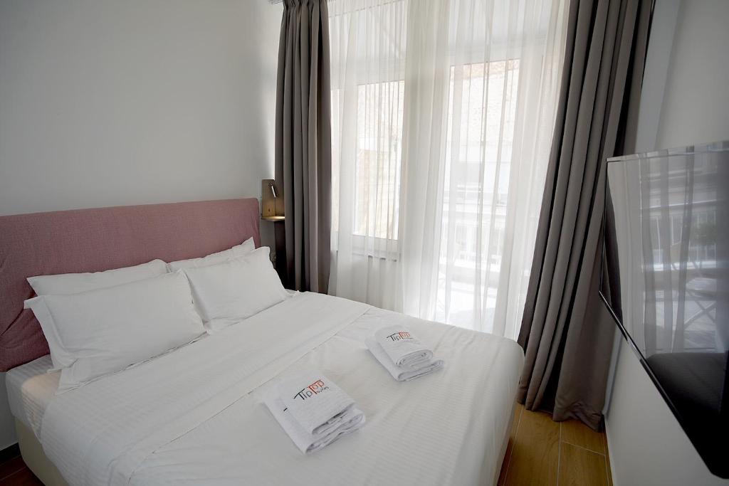 a bedroom with a white bed with two towels on it at TiP - ToP Suites in Athens