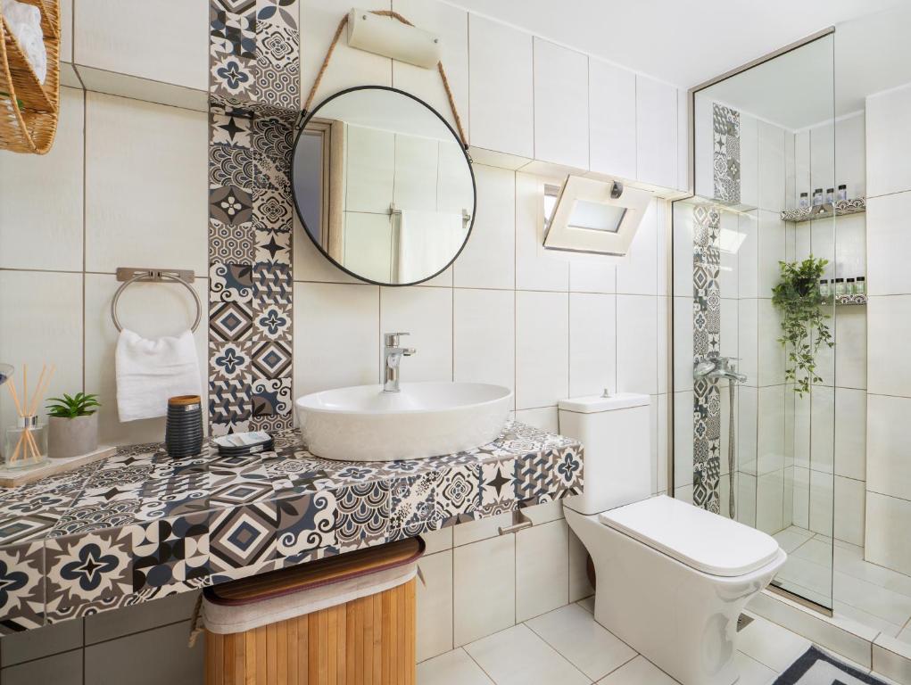 a bathroom with a sink and a toilet and a mirror at Jasmine loft luxury 1 in Kokkini Khanion