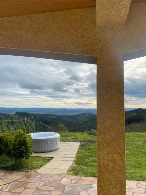 uma vista do pátio de uma casa com uma banheira de hidromassagem em Grande maison récente avec vue em Saint-Hilaire