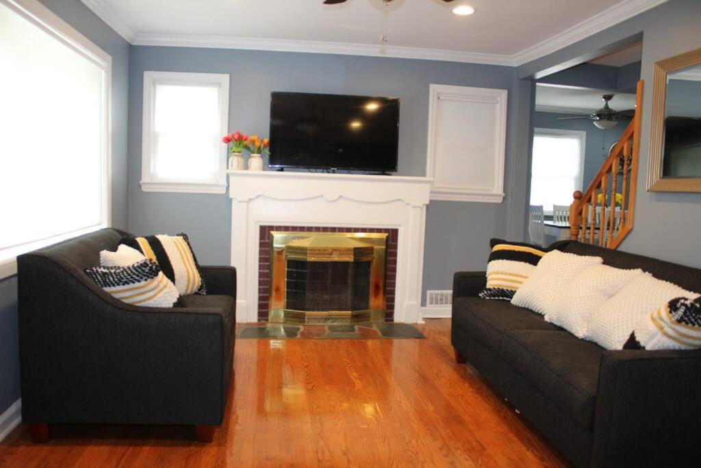 a living room with two couches and a fireplace at Beautiful place minutes away to New York City . in Teaneck