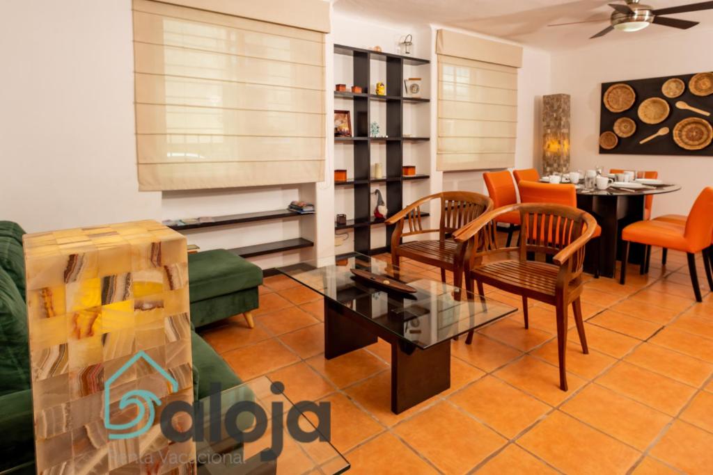 Apartamento amplio en zona ideal a 5min de WALLMART في كانكون: غرفة معيشة مع أريكة وكراسي وطاولة