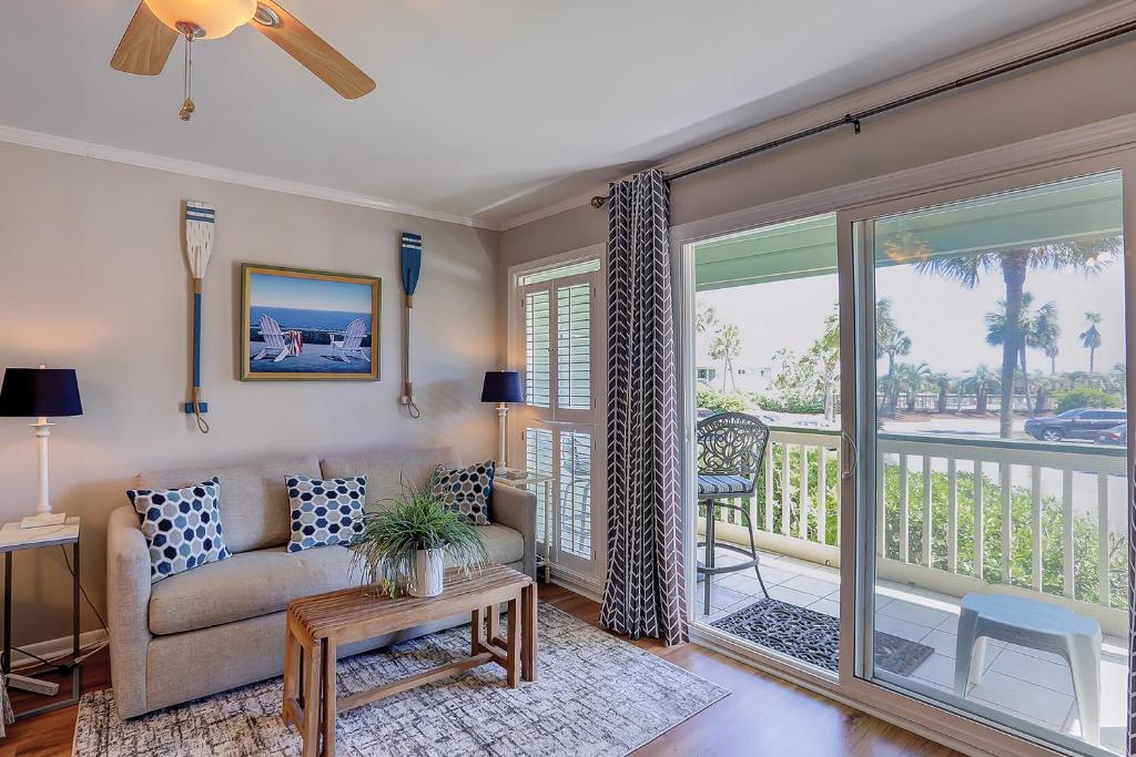 a living room with a couch and a balcony at Sea Cabin 131 B in Isle of Palms