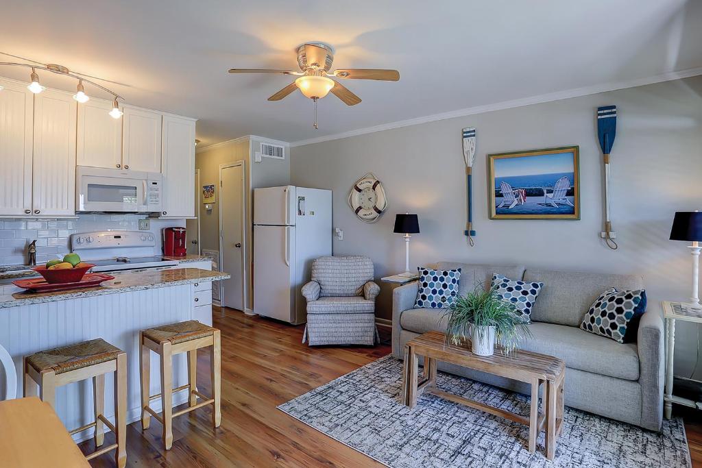 a living room with a couch and a kitchen at Sea Cabin 131-B in Isle of Palms