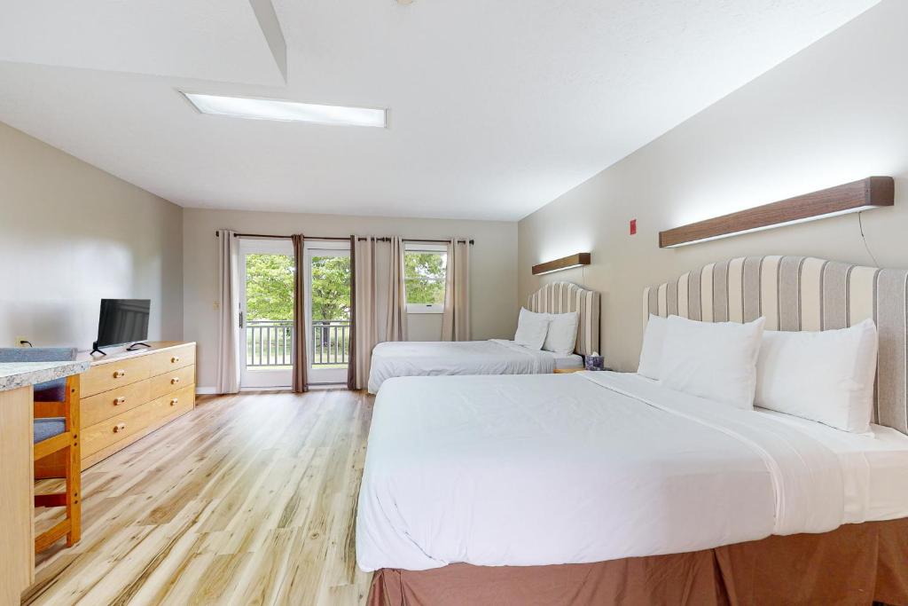 a large bedroom with two beds and a television at Baneberry Inn 4 in White Pine