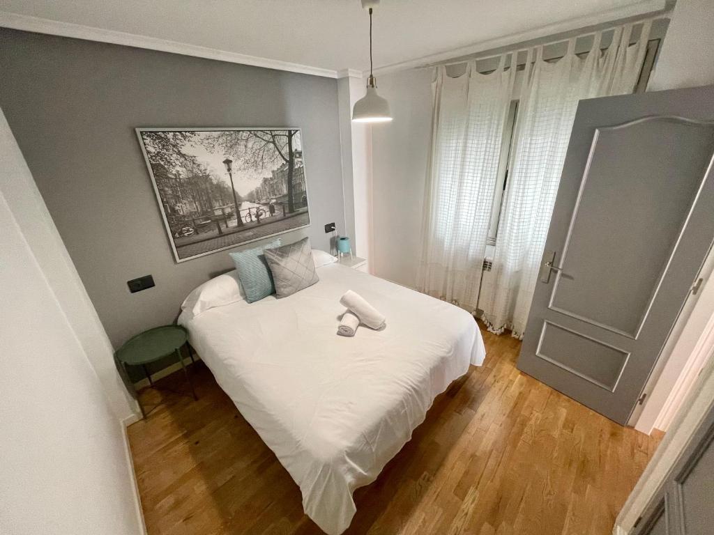 a bedroom with a bed with two towels on it at Apartamento Jardín de San Feliz / Fontán in Oviedo