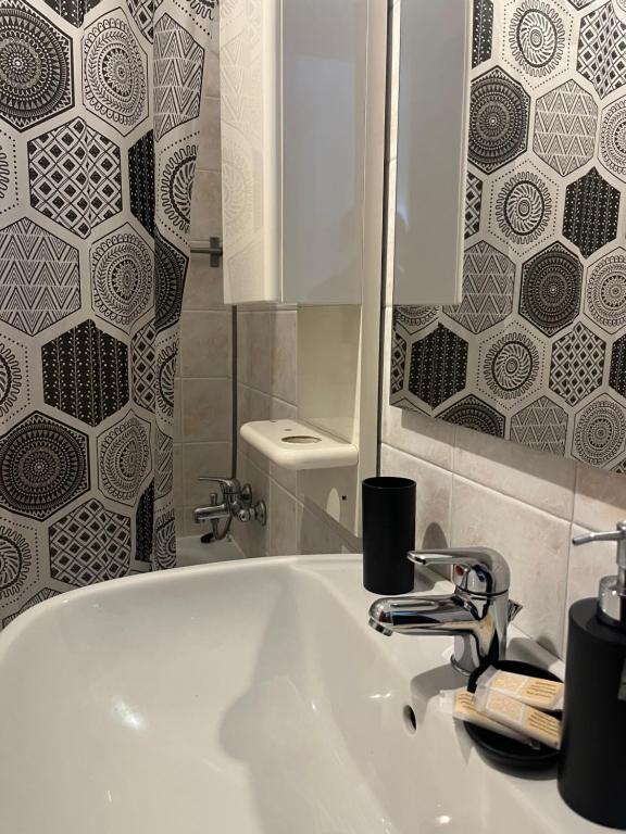 łazienka z białą umywalką i lustrem w obiekcie Joya apartament w mieście Tarent