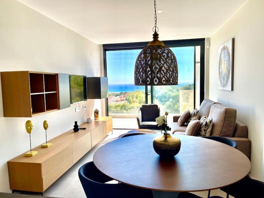 uma sala de estar com uma mesa e uma grande janela em Apartamento Sukha Vistas al Mar em Gran Alacant