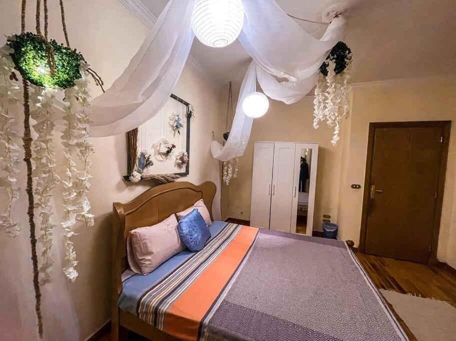 um quarto com uma cama de dossel e cortinas em Flowered private room no Cairo