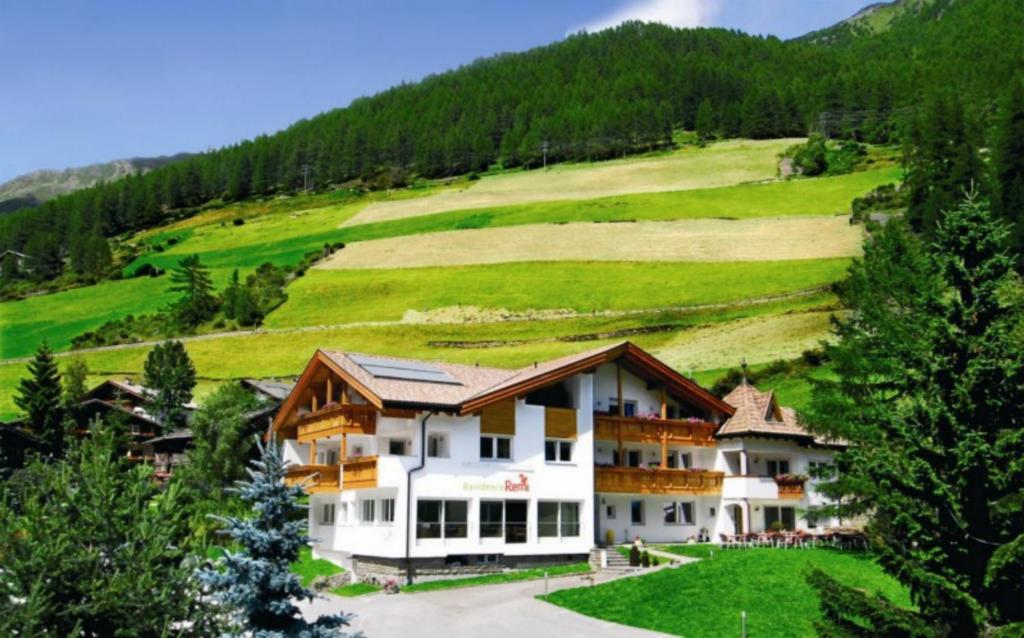 a hotel in the mountains with a hill in the background at Residence Remi in Senales