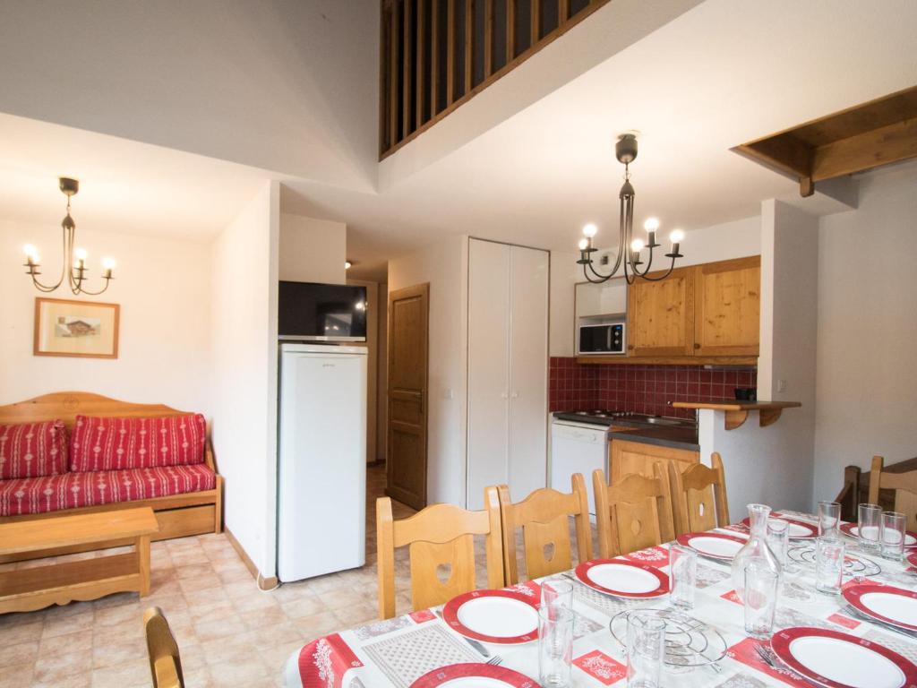 une salle à manger et une cuisine avec une table et des chaises dans l'établissement Duplex pour 10 pers, au pied des pistes, proche télécabine et commerces, parking inclus - FR-1-508-16, à Lanslevillard