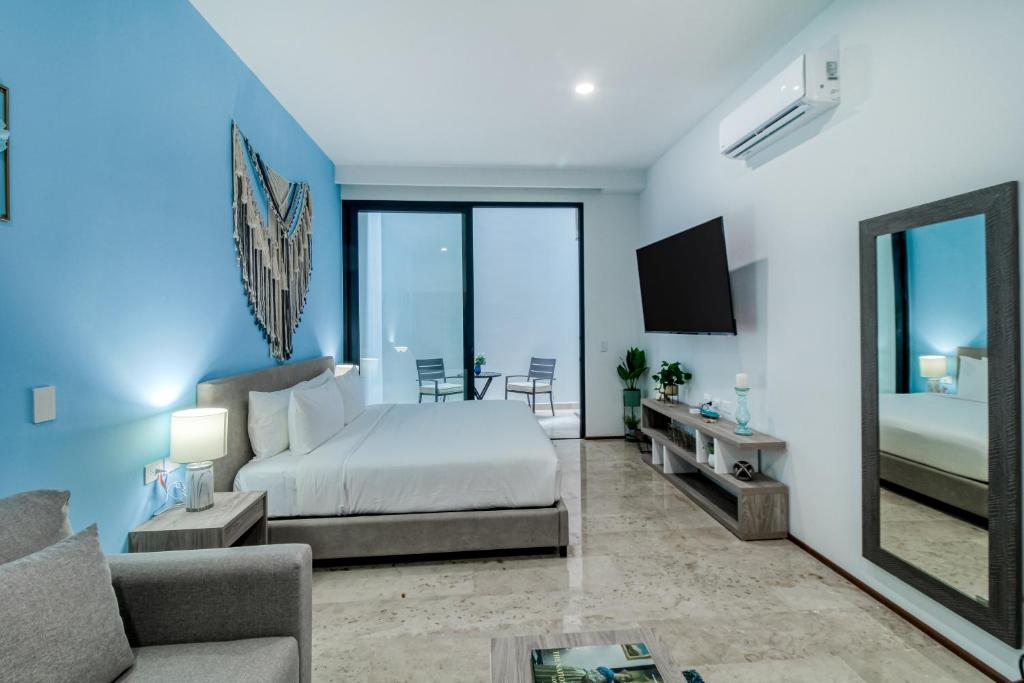 une chambre avec un lit, un canapé et un miroir dans l'établissement The Perfect Place, Unit 005, à Playa del Carmen