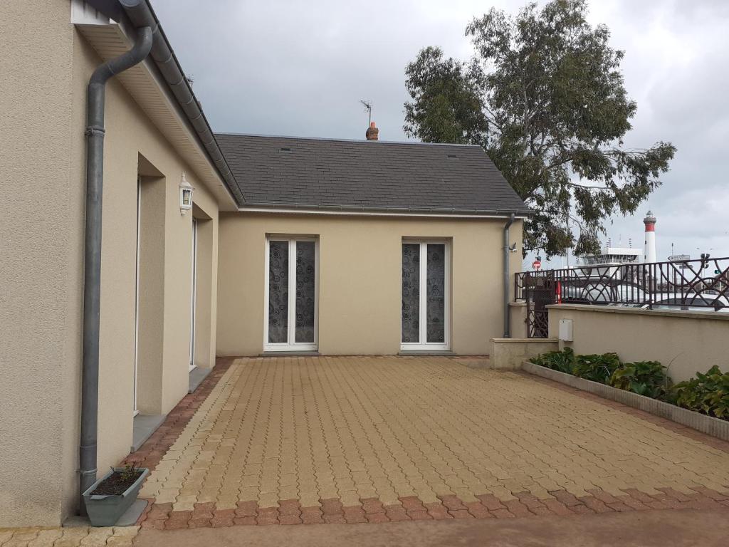 une maison avec une allée en briques devant elle dans l'établissement Ouistreham (14) Maison en bord de mer - 6 personnes, à Ouistreham