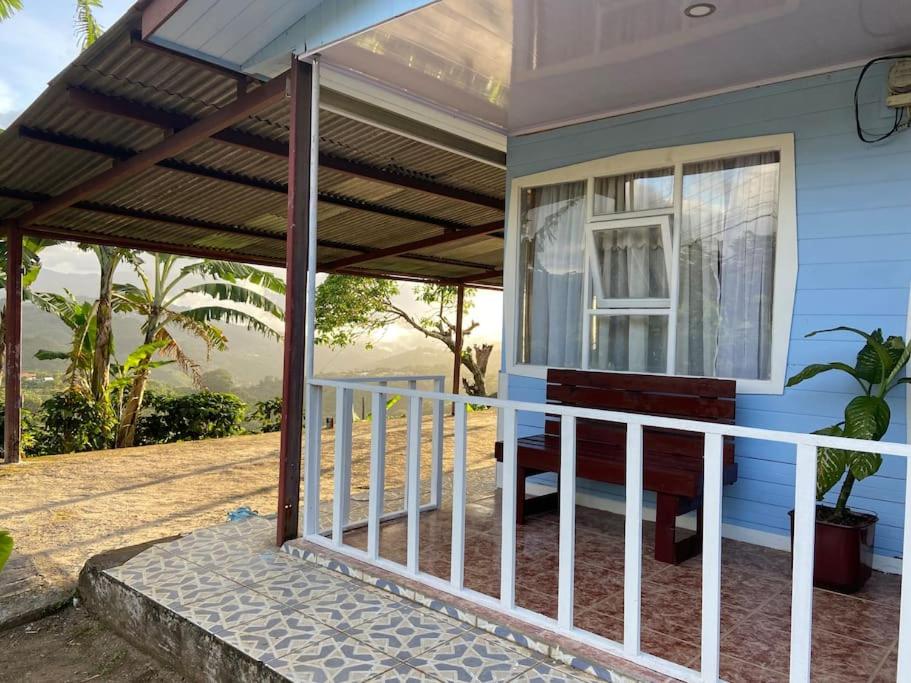 a porch of a blue house with a balcony at Casa Vista Cafe in Cartago