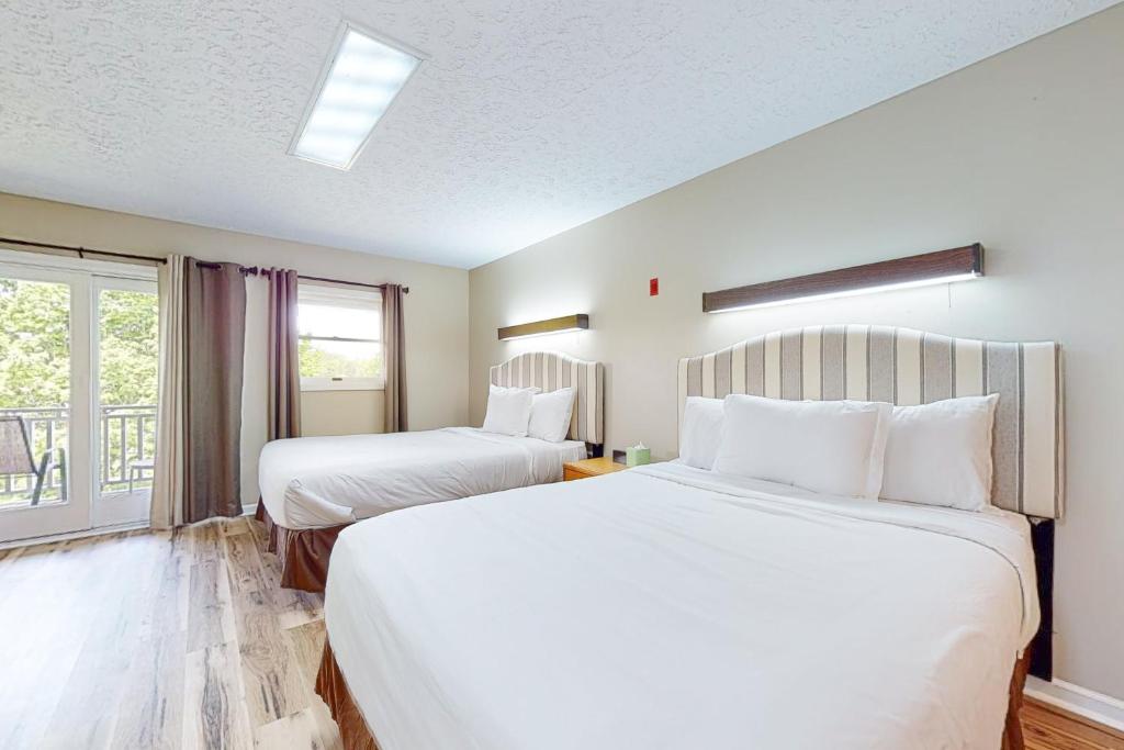 um quarto de hotel com duas camas e uma janela em Baneberry Inn 10 em White Pine