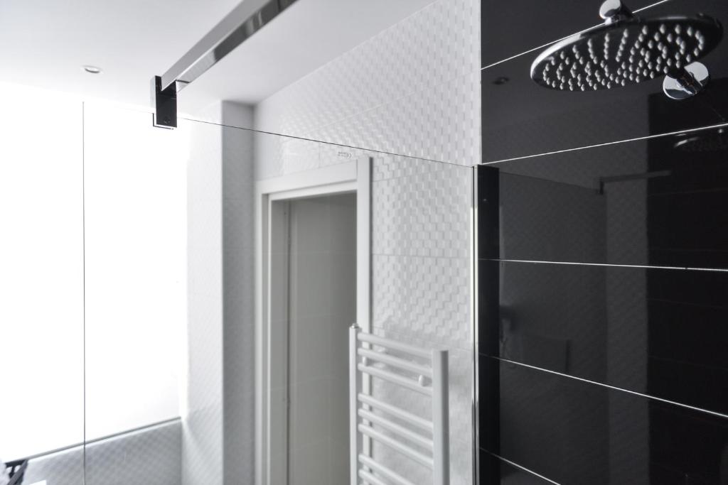W łazience znajduje się lustro oraz ściany wyłożone czarno-białymi kafelkami. w obiekcie Lata Luxury Rooms w Rzymie