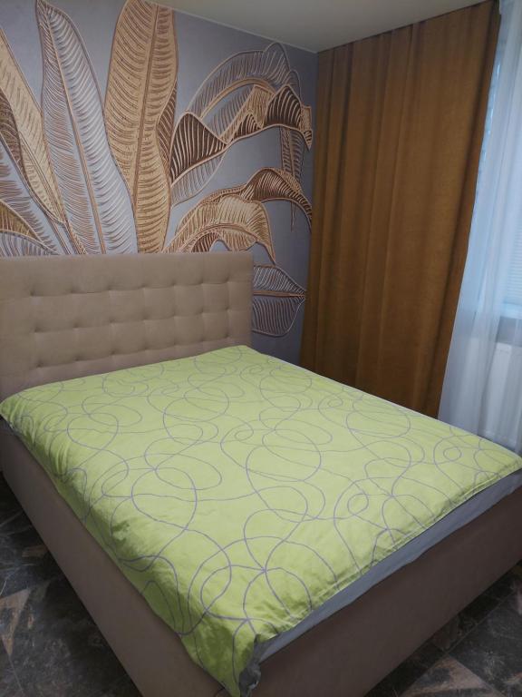 1 dormitorio con 1 cama con colcha verde en Сучасні апартаменти Палац Спорту, en Járkov