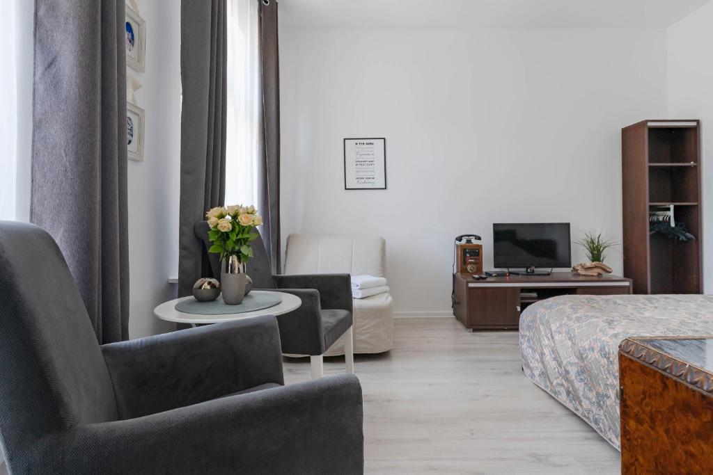 a hotel room with a bed and a living room at Kierunek Sopot Apartament WERANDA Haffnera 32 in Sopot