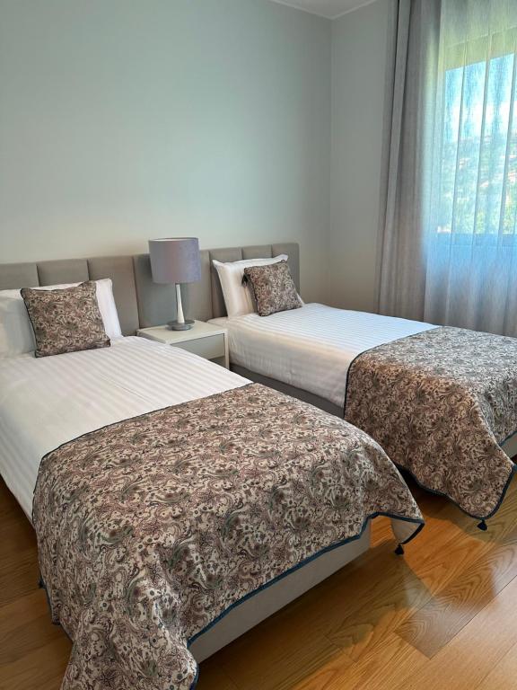 um quarto com 2 camas e uma janela em Leonor Seaview Apartment no Funchal