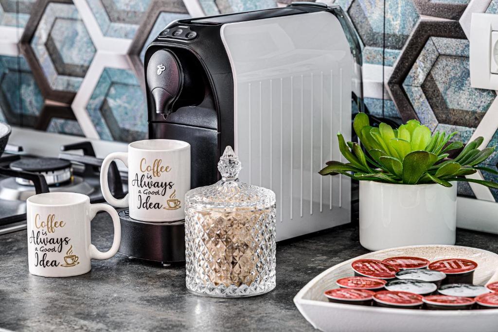 a counter with two coffee mugs and a toaster at ARI AQUA APARTMENT in Arad