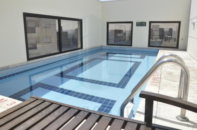 una gran piscina con un banco en un edificio en Studio Living Faria Lima, en São Paulo