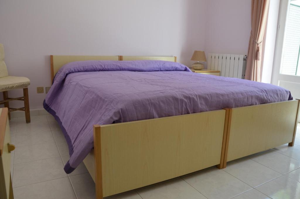 a bed with a purple comforter in a bedroom at U Campagnuolo in Ischia