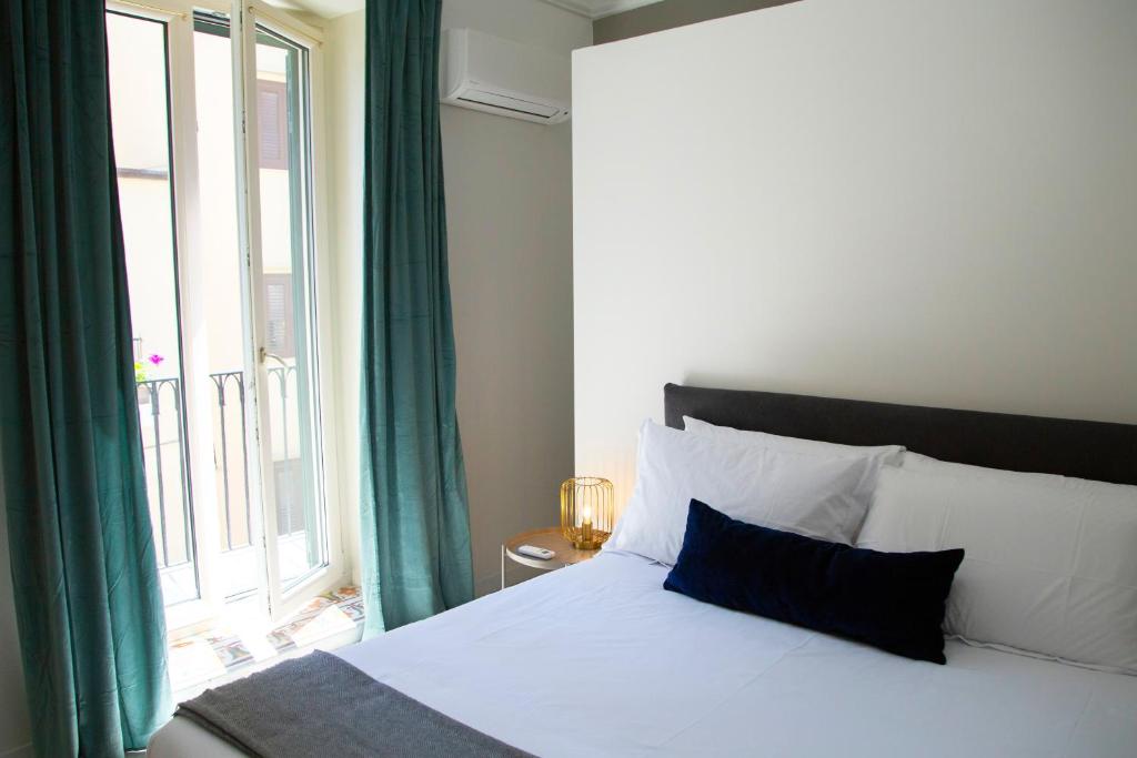 een slaapkamer met een bed met een groot raam bij Cassari 61 in Palermo