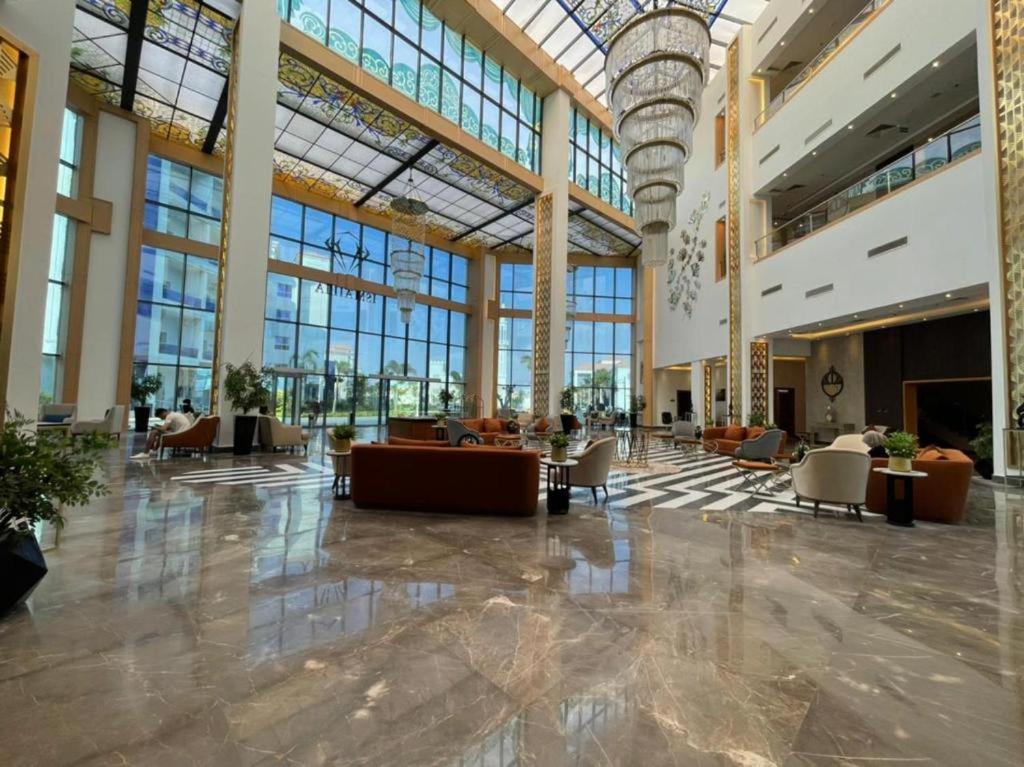 a large lobby with tables and chairs and windows at Golden Jewel Ismailia Resort in Ismailia