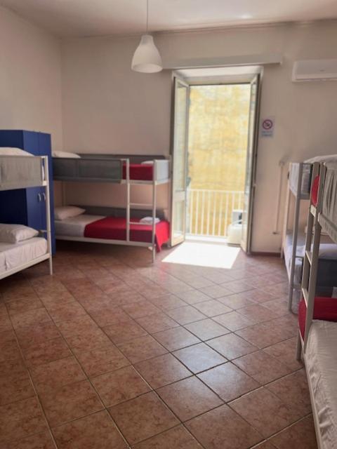 a room with bunk beds and a hallway with a door at Coremi in Naples