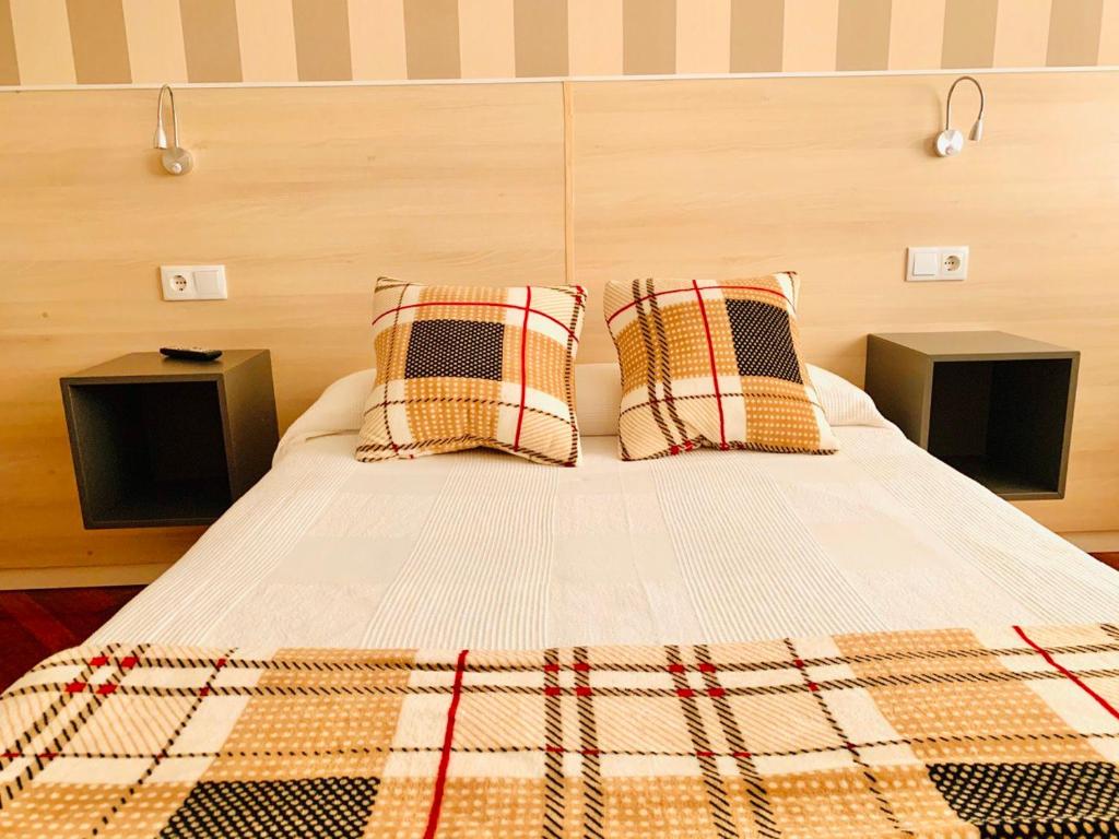 a bed with two pillows on top of it at Family & Groups Space, Santiago Center - No Kitchen in Santiago de Compostela
