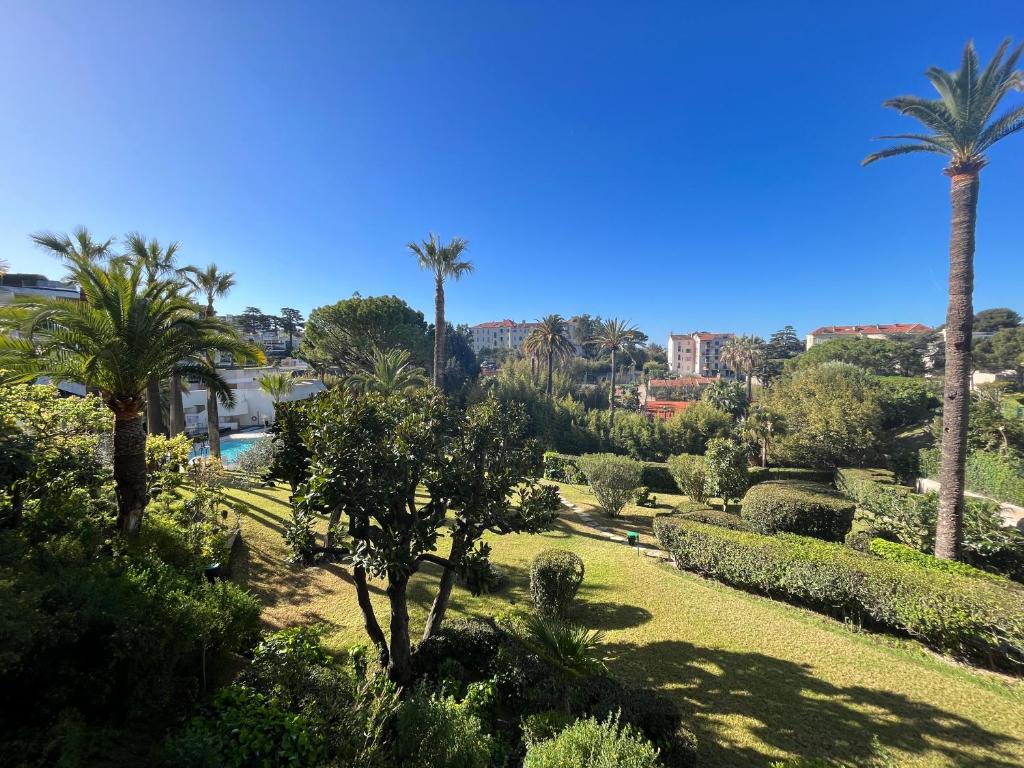 a garden with palm trees and bushes on a sunny day at Parc Montfleury in Cannes