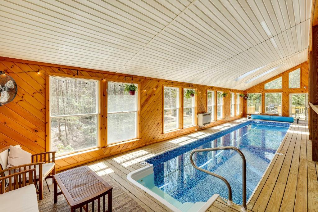 una piscina en una casa con paredes de madera en Lake George Oasis with 9 Acres, Hot Tub and Game Room!, en Diamond Point
