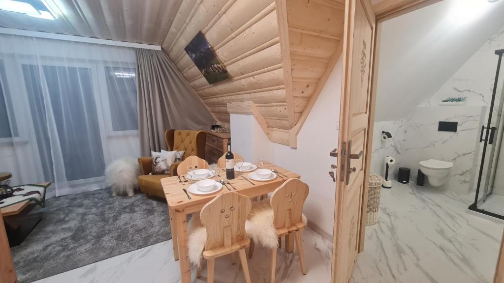 Habitación pequeña con mesa de madera y sillas. en Pokoje Kubikowe en Ząb