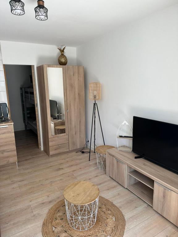 - un salon avec une télévision et un miroir dans l'établissement Charmant studio neuf 150m plage sur avenue principale climatisé et parking, à Cavalaire-sur-Mer