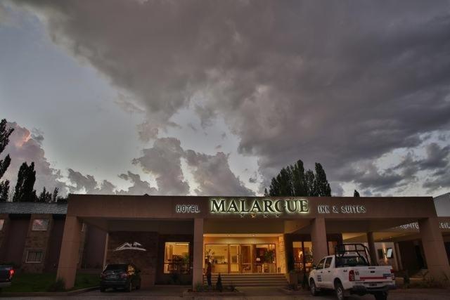 ein großes Gebäude mit einem davor geparkt in der Unterkunft Hotel Malargue in Malargüe