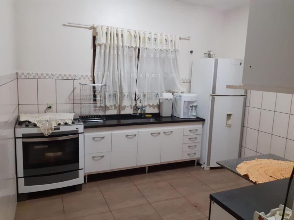 uma cozinha com um fogão e um frigorífico em Chácara com Piscina em Araçoiaba da Serra