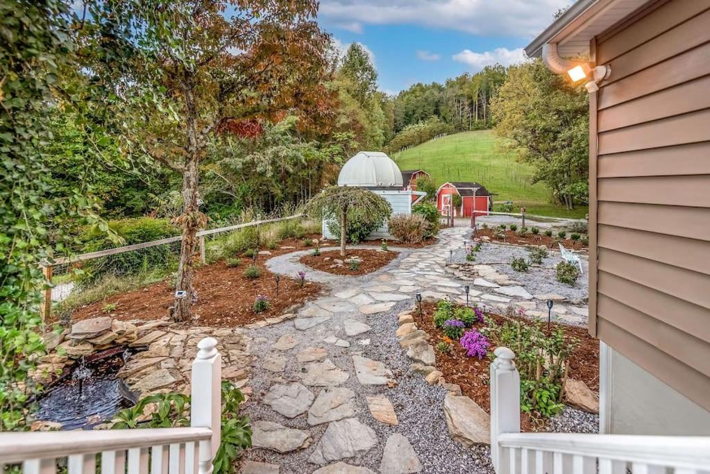 un giardino con sentiero in pietra e recinzione di 40 Acres w/Waterfalls, Vineyard, Stream, 5 bedroom a Moravian Falls