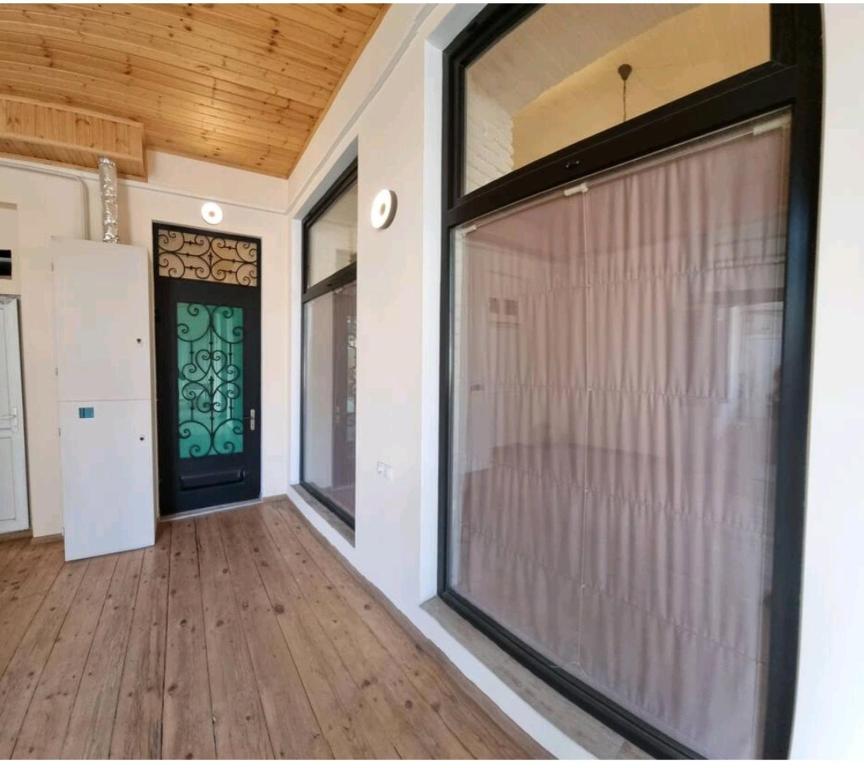 Una gran puerta de vidrio en una casa con piso de madera. en Plexanovi Apart, en Tiflis