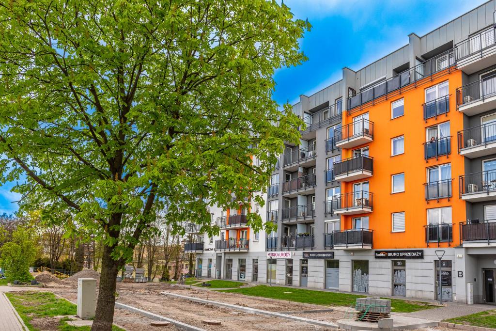 an orange building with a tree in front of it at Apartament Graniczna 6B in Bydgoszcz