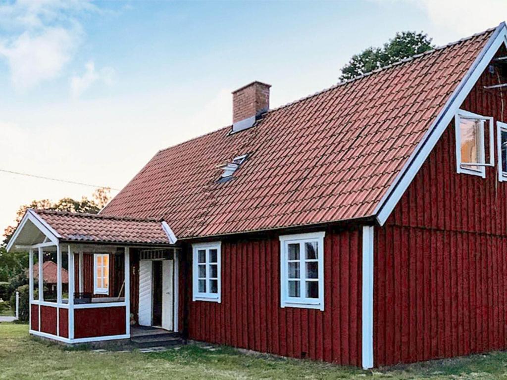 ein rotes Haus mit rotem Dach in der Unterkunft Holiday home Ljungbyhed III in Ljungbyhed