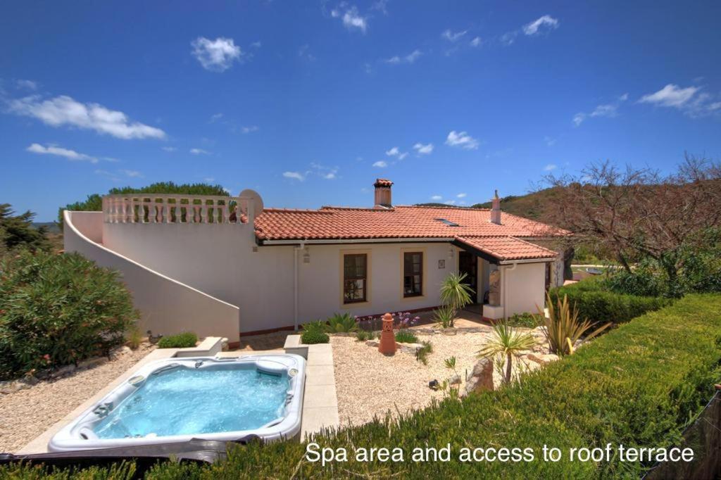 a villa with a swimming pool in front of a house at Quinta Casa May in Budens