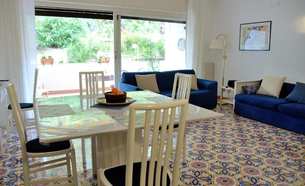 sala de estar con mesa y sofá azul en Sea Breeze Acitrezza, en Aci Castello