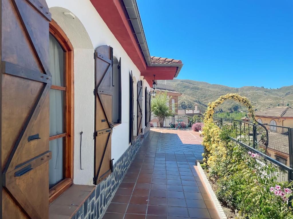 a walkway next to a building with a window at Casa rural VISTABLANCA en una sola planta con bonitas vistas y piscina - Junto a la capital y la Alhambra in Cenes de la Vega
