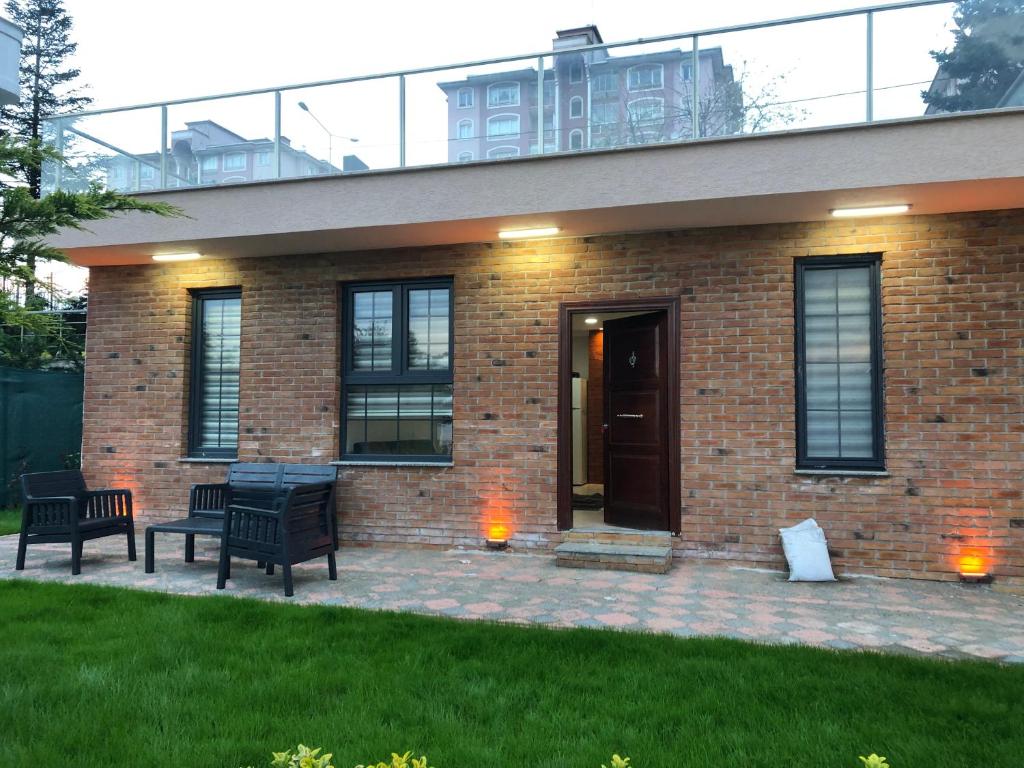 a brick house with two benches in front of it at seyran 3 in Trabzon