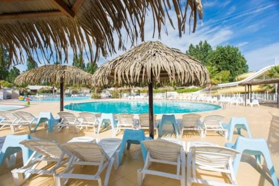 een groep stoelen en parasols naast een zwembad bij Azur in Fréjus
