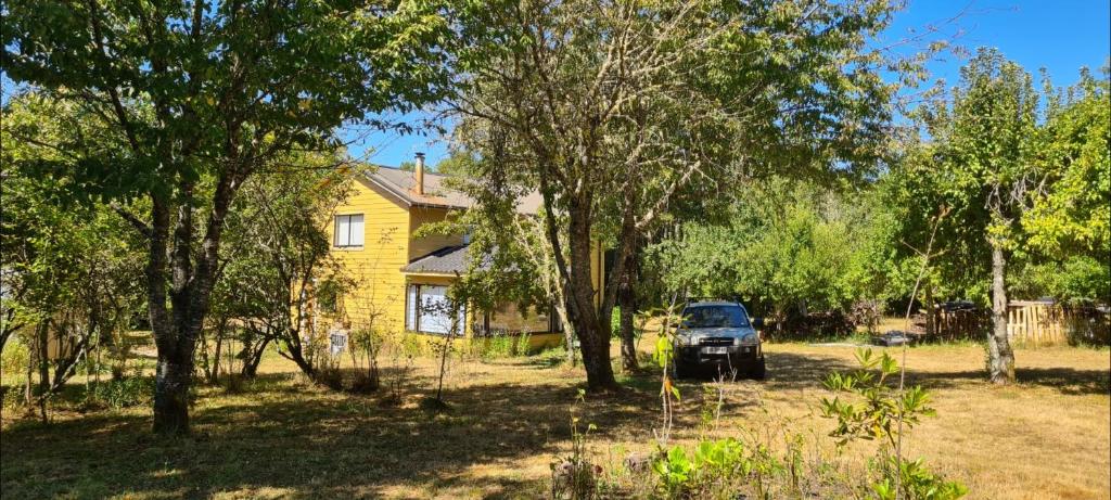 un camión estacionado frente a una casa amarilla en Casa Selva en Valdivia